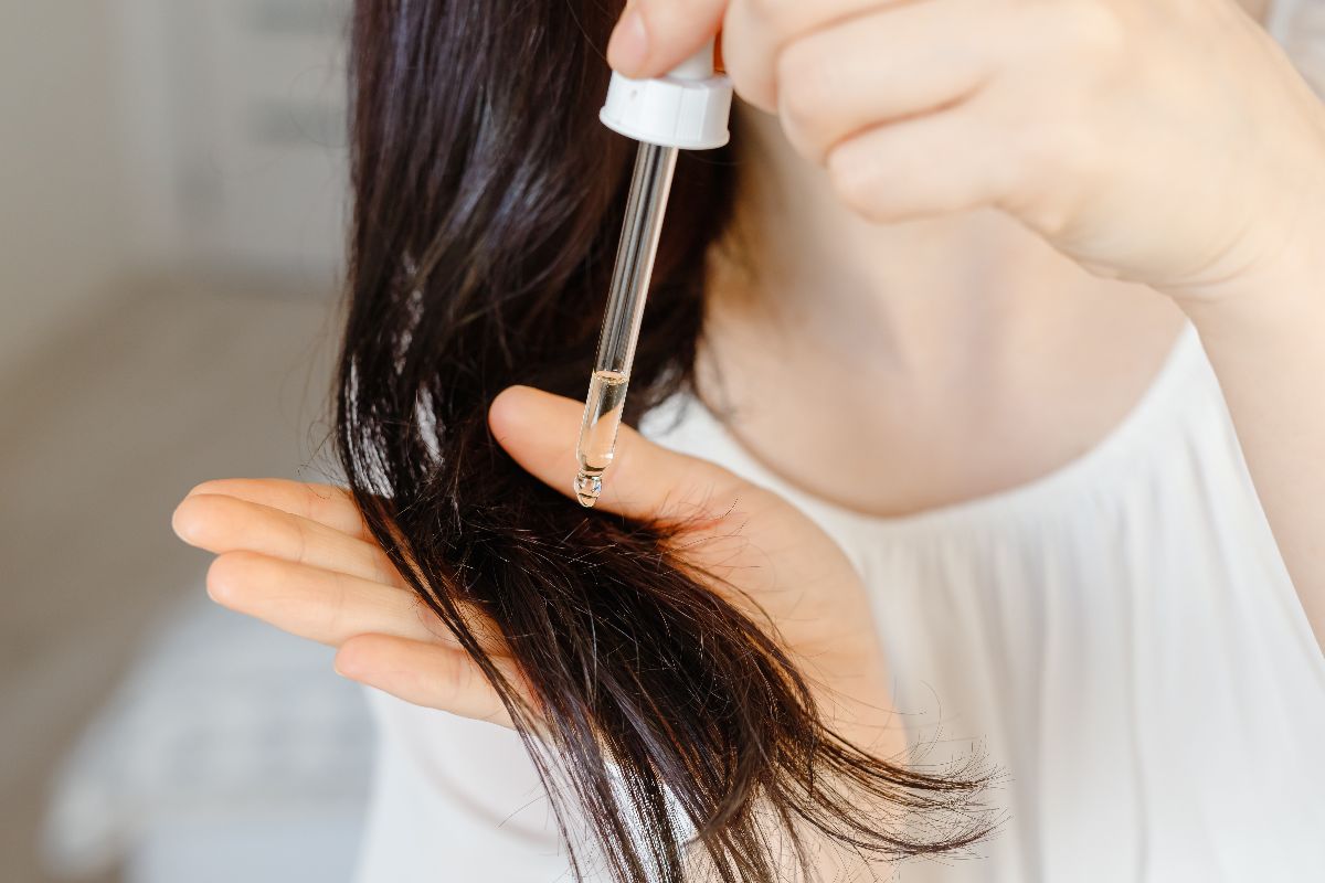 A young woman incorporating hair oil to her daily routine